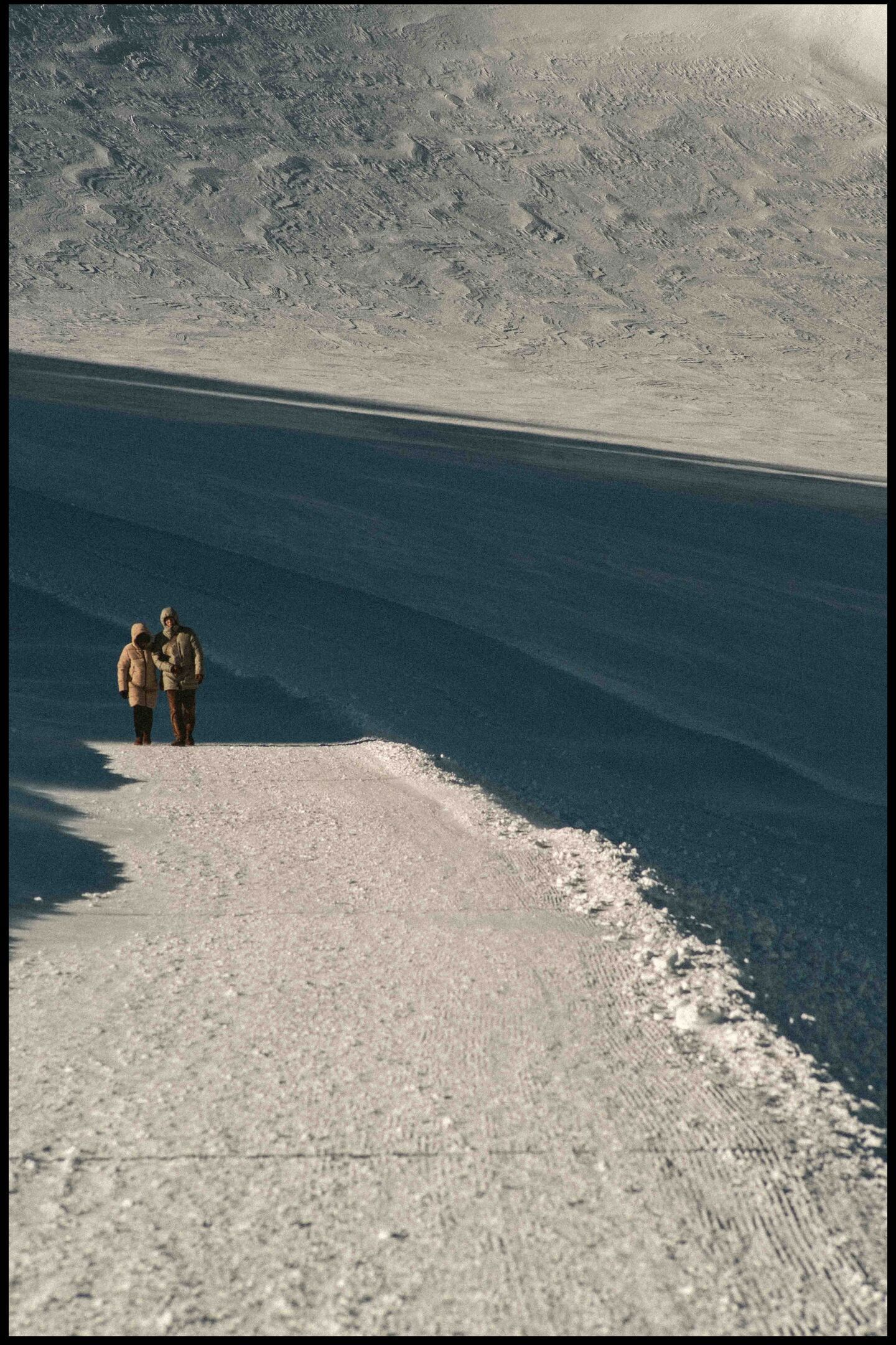 a couple is walking down a glacier path